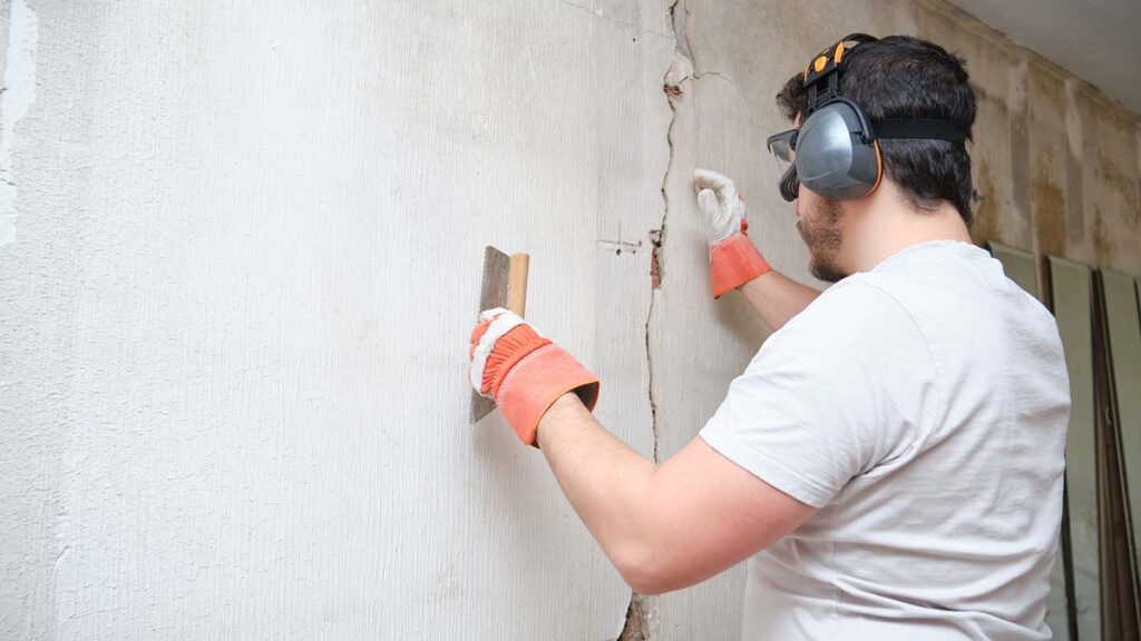 concrete contractor repairing a crack in the foundation wall