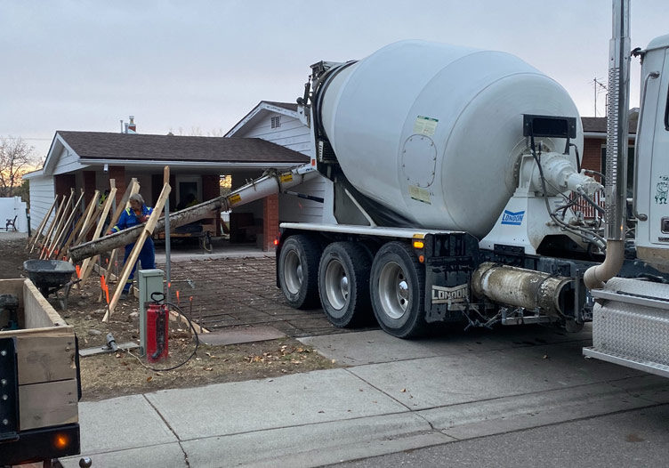 concrete mixer pouring out a new driveway for a residential home